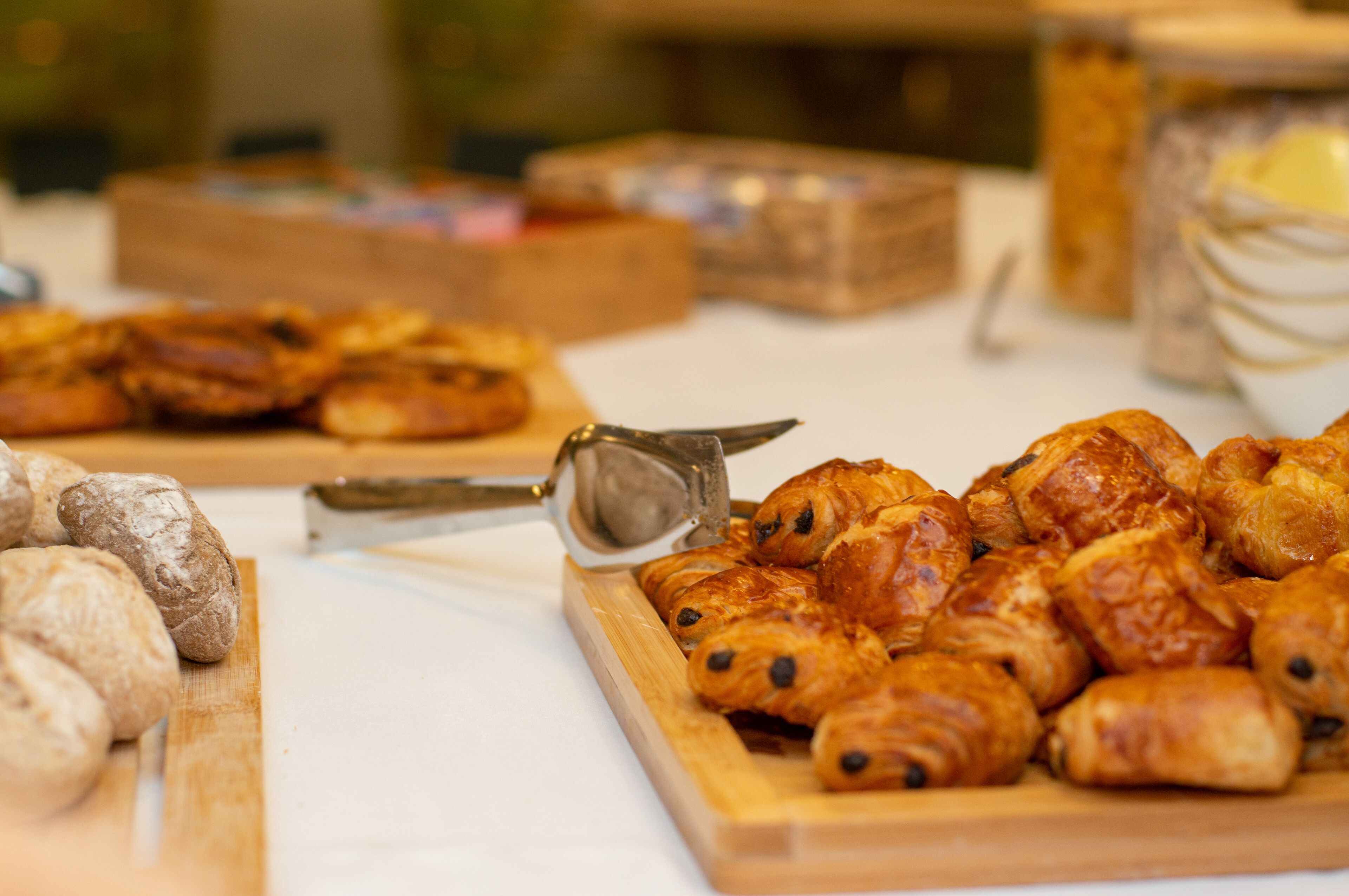 A variety of pastries on a table, including croissants and bread rolls.