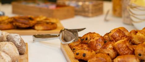 A variety of pastries on a table, including croissants and bread rolls.