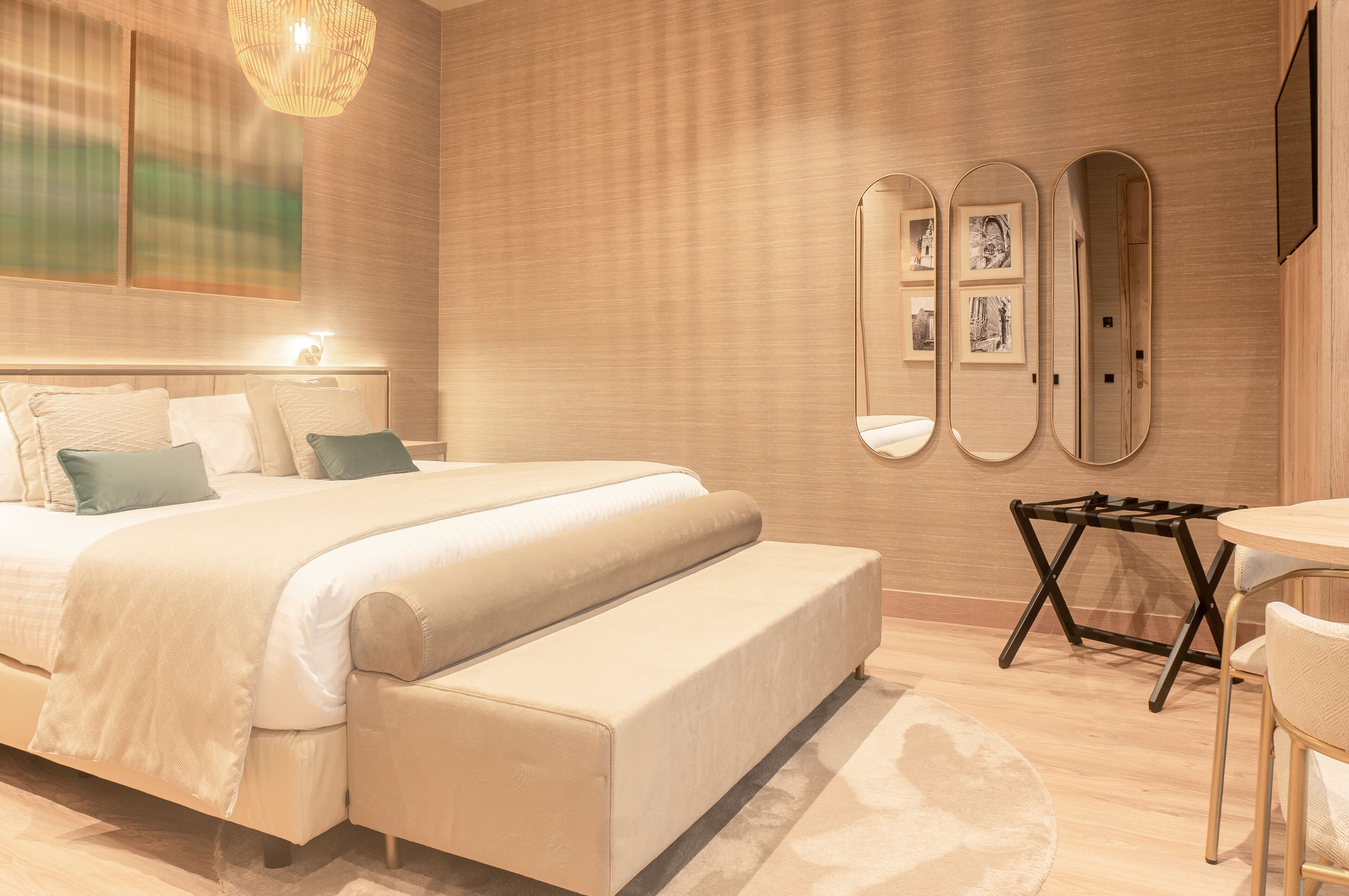 Un dormitorio moderno con una cama grande, mesitas de noche, un escritorio y una silla.