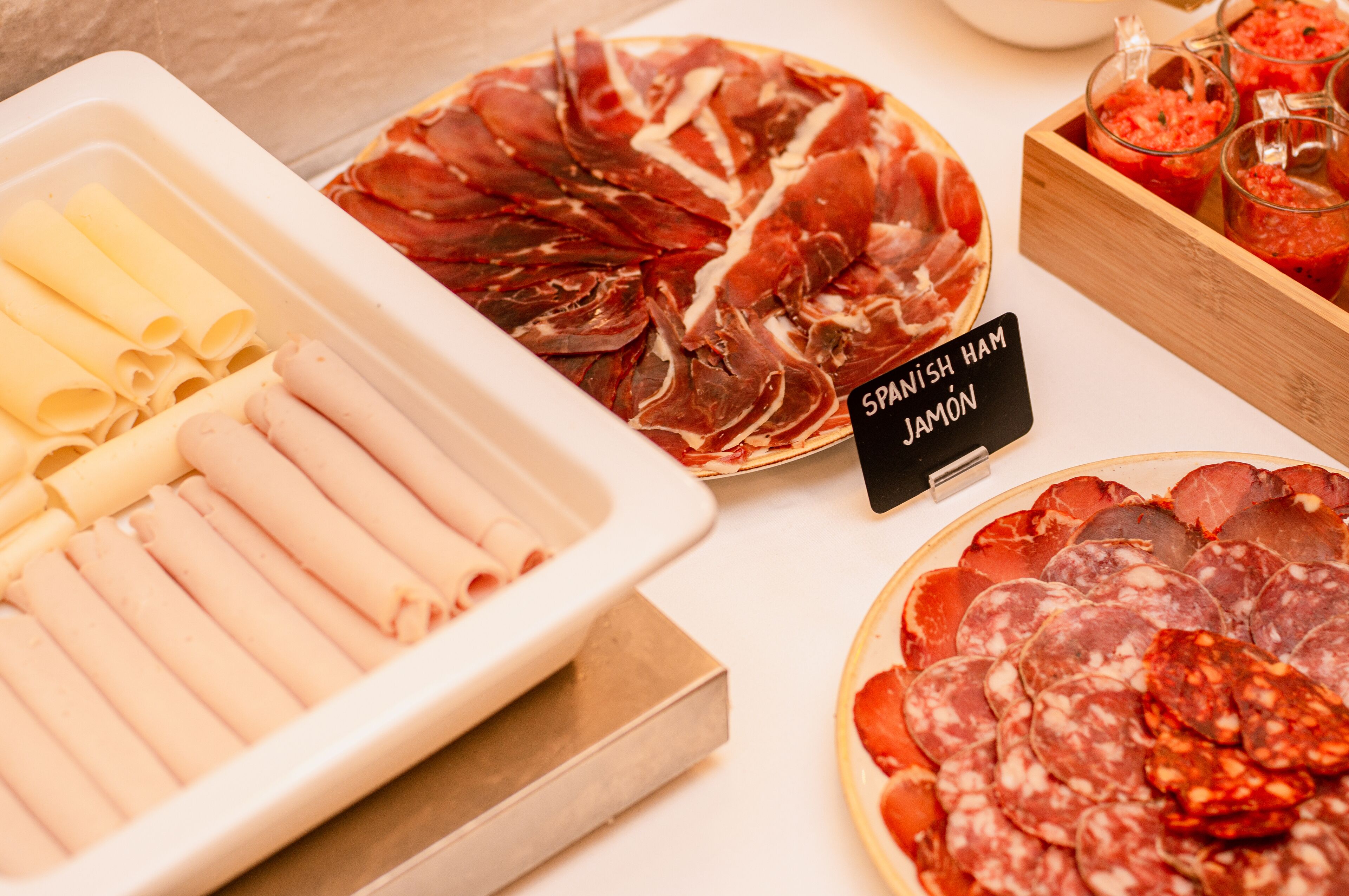 Une variété de charcuteries et de fromages sont exposés.