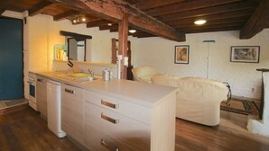 A kitchen with wooden beams, a white countertop, and a sink.