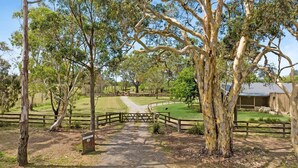 A rural property with a gravel path leading to a wooden gate, surrounded by trees and a fenced area. - Fentons Run, High Range, Southern Highlands (High Range)