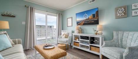 Relax in this inviting living room with a comfortable sofa set, stylish armchair, and large window offering a view of the outside.