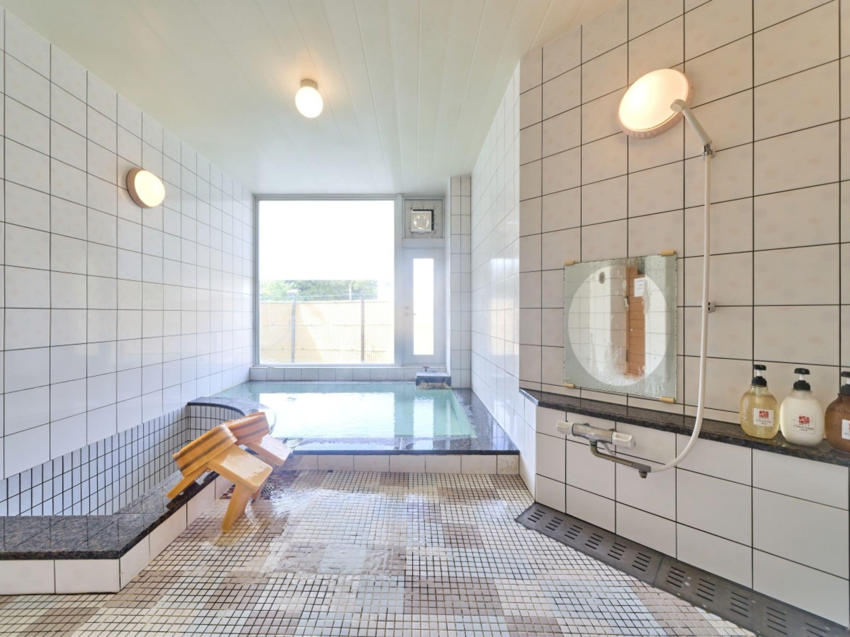 Un bagno moderno con un'ampia finestra, una panca e uno specchio.
