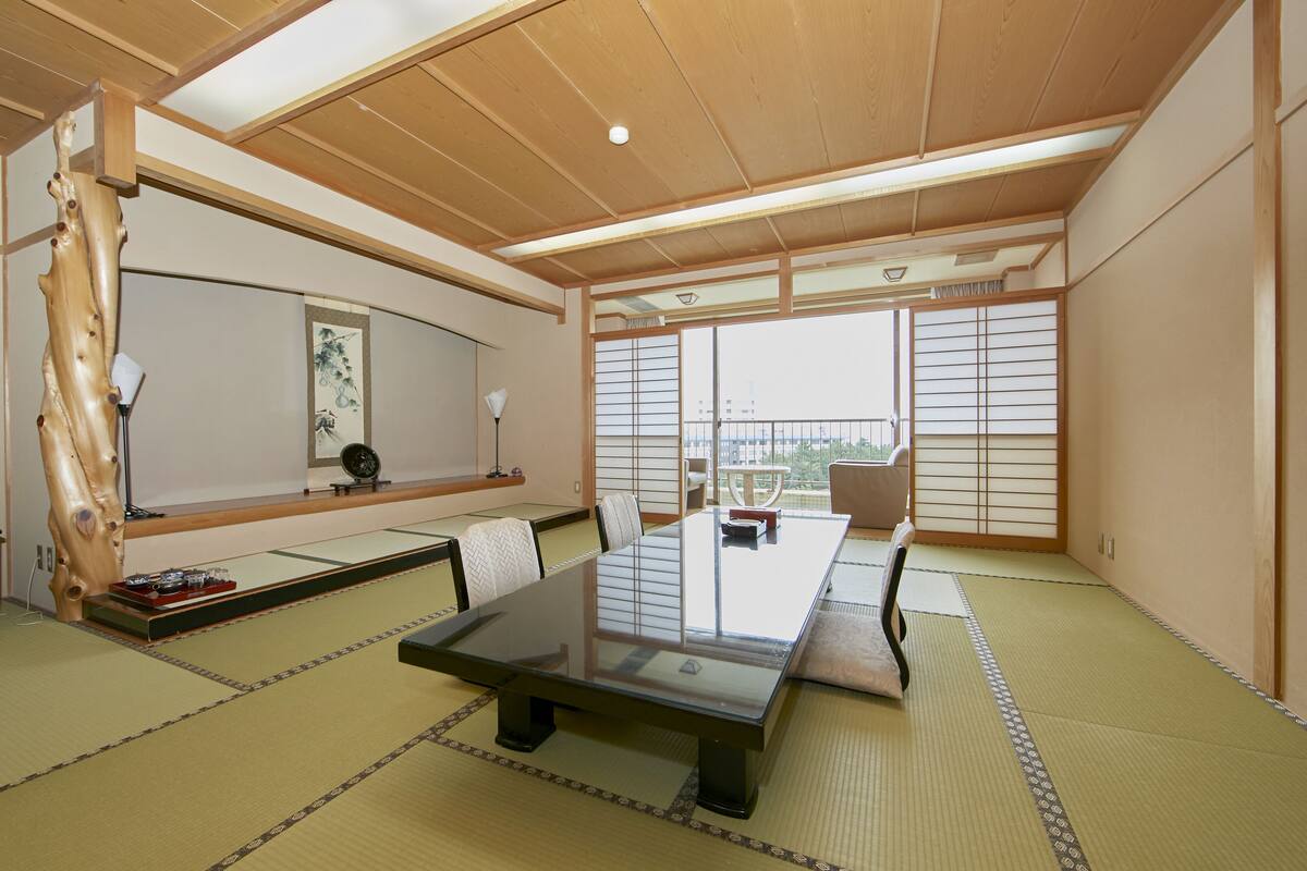 A traditional Japanese-style meeting room with tatami flooring, a low table, and shoji screens.