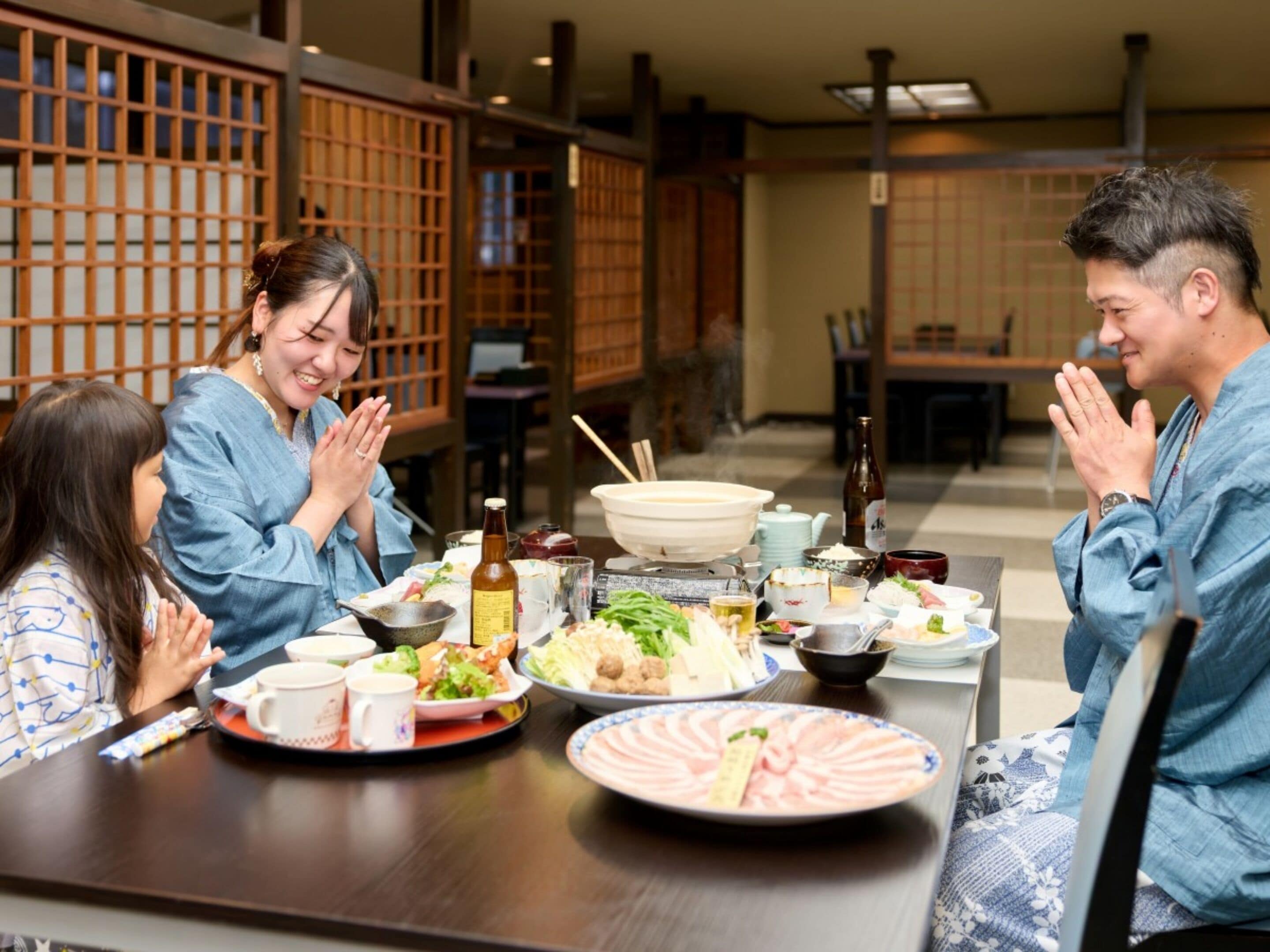 A traditional Japanese dining setting with a wooden table, various dishes, and a bottle.