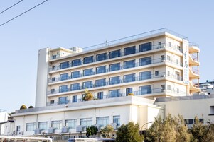Un hotel de varios pisos con balcones y unidades de aire acondicionado.