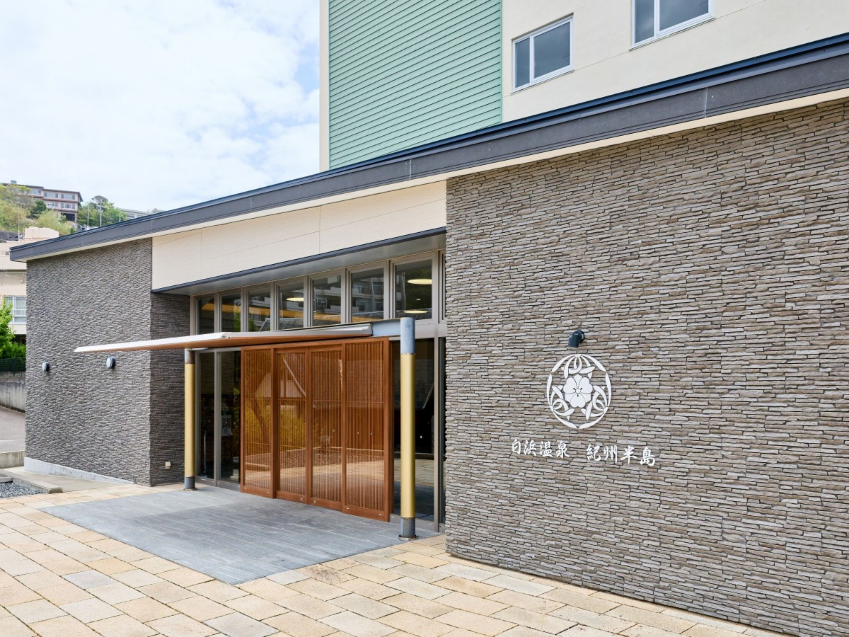 A building with a stone facade, a wooden entrance, and a logo with Chinese characters.
