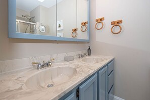 A bathroom with two sinks, a large mirror, and wooden towel rings. - Dog-Friendly house. Arctic Ave House: Sunny and bright beautiful 4 Bedroom 3 Full bathroom single home walking distance to the beach, Free WiFi, linens included. Remodel just in couple month. Great location, walk in to restaurants, coffee shop, Acme (Ocean City)