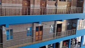 Un edificio de varios pisos con fachada azul y varios balcones.