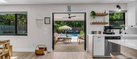 A modern kitchen with a view of a pool and outdoor seating area.