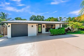 Een gelijkvloers huis met garage, voordeur en klein portaaltje.