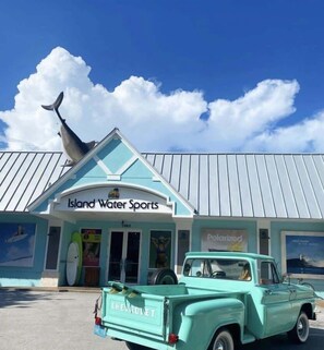A turquoise Chevrolet truck parked in front of a building with a sign reading "Island Water Sports".