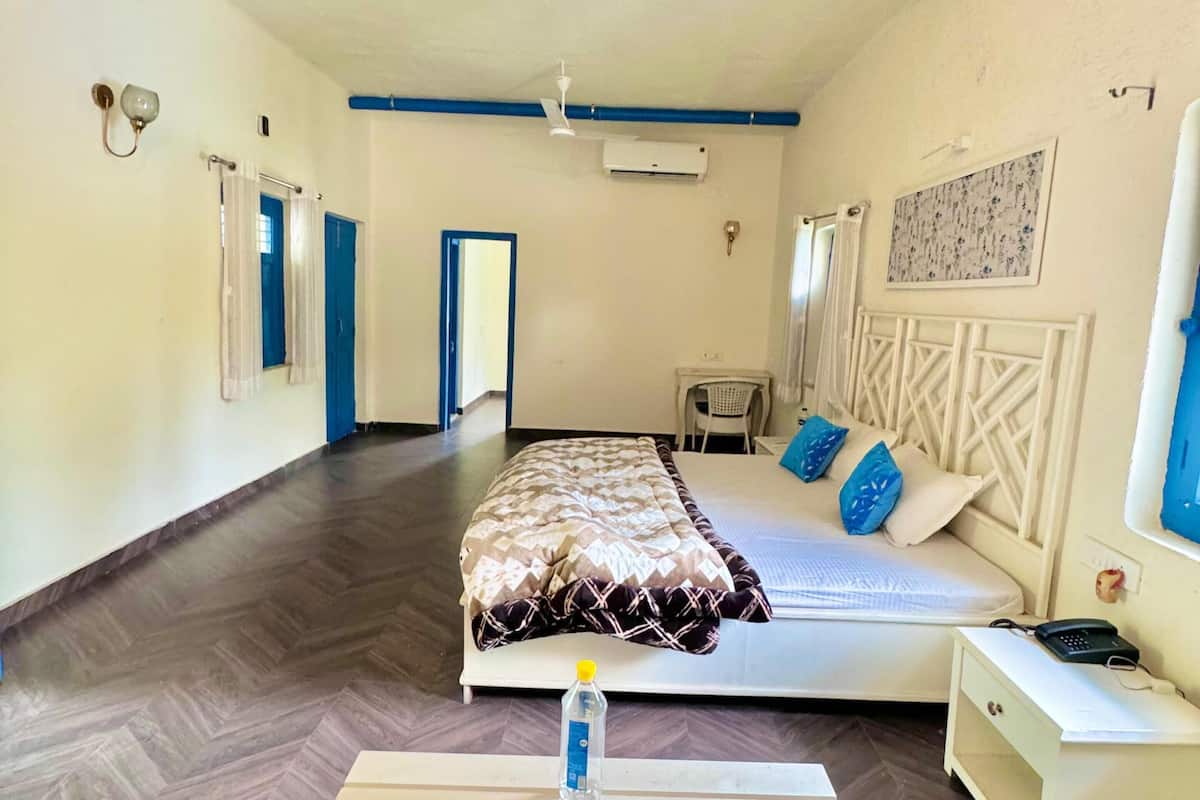 A bedroom with a bed, bedside table, and a ceiling fan.