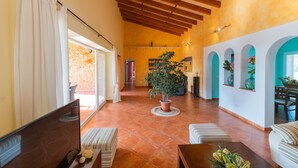 A spacious living area with a wooden ceiling, a potted plant, and a dining table. - Marina Calas de Mallorca (Calas de Mallorca)