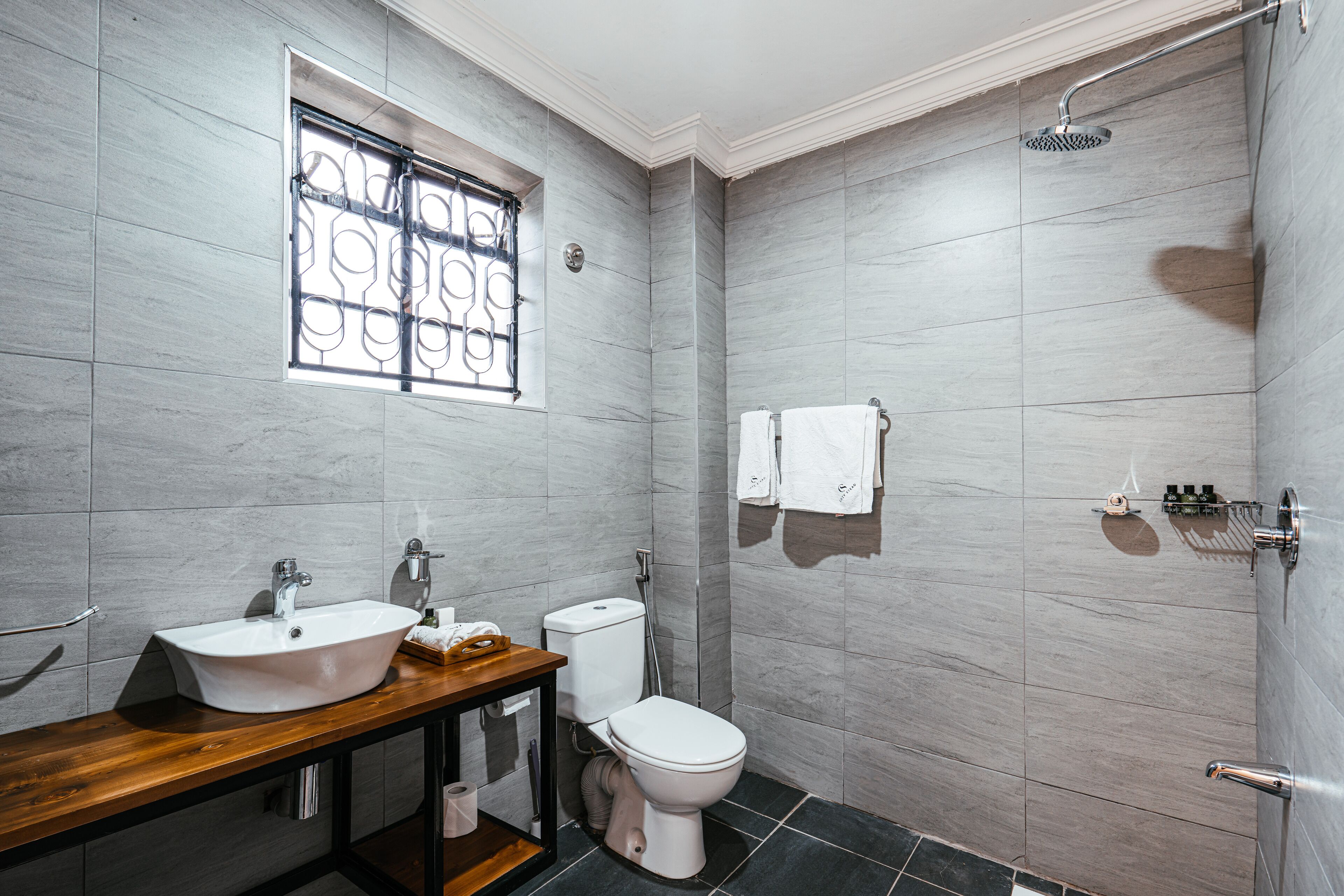 A modern bathroom with a vanity, sink, toilet, and shower.