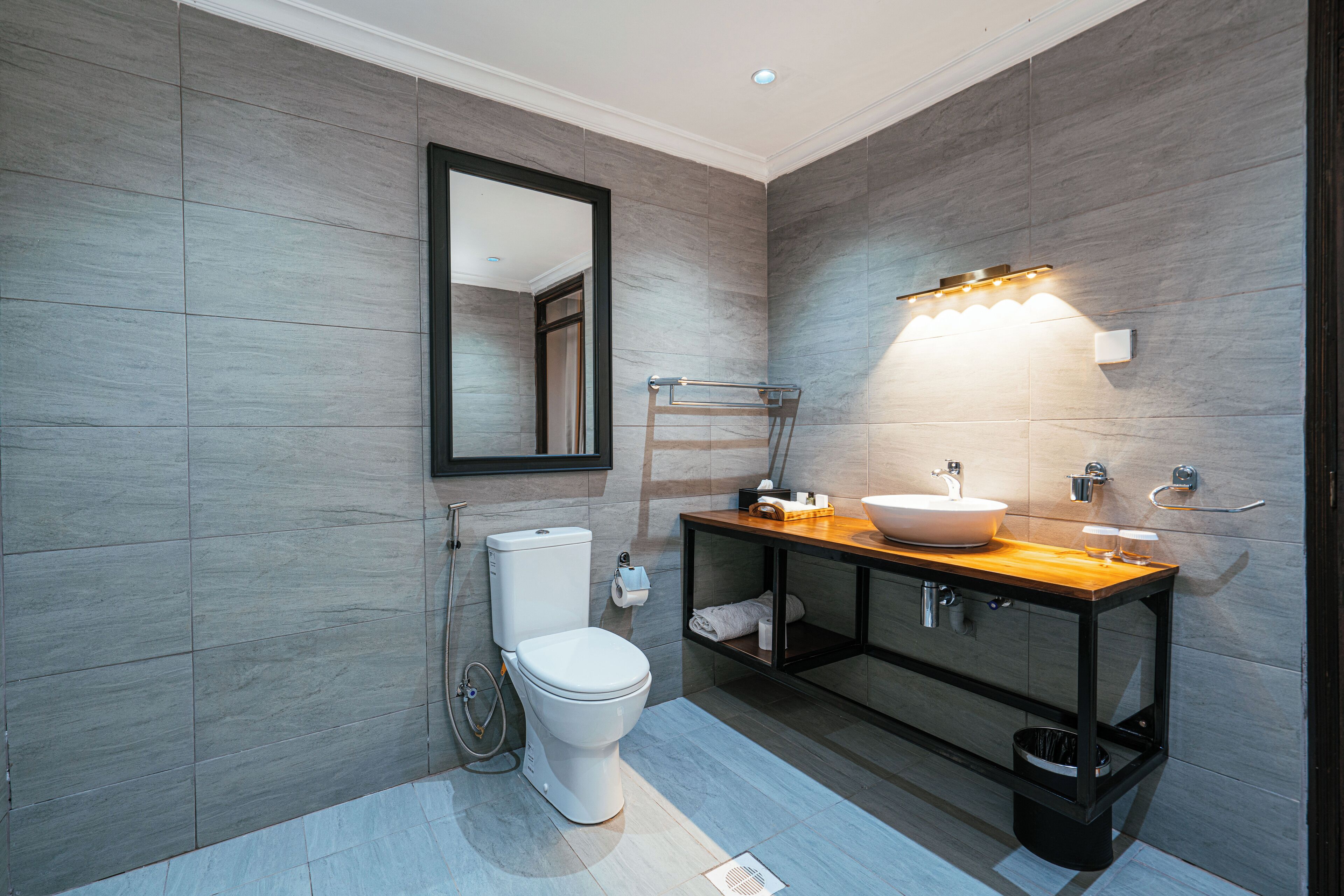 A modern bathroom with a toilet, sink, and mirror.