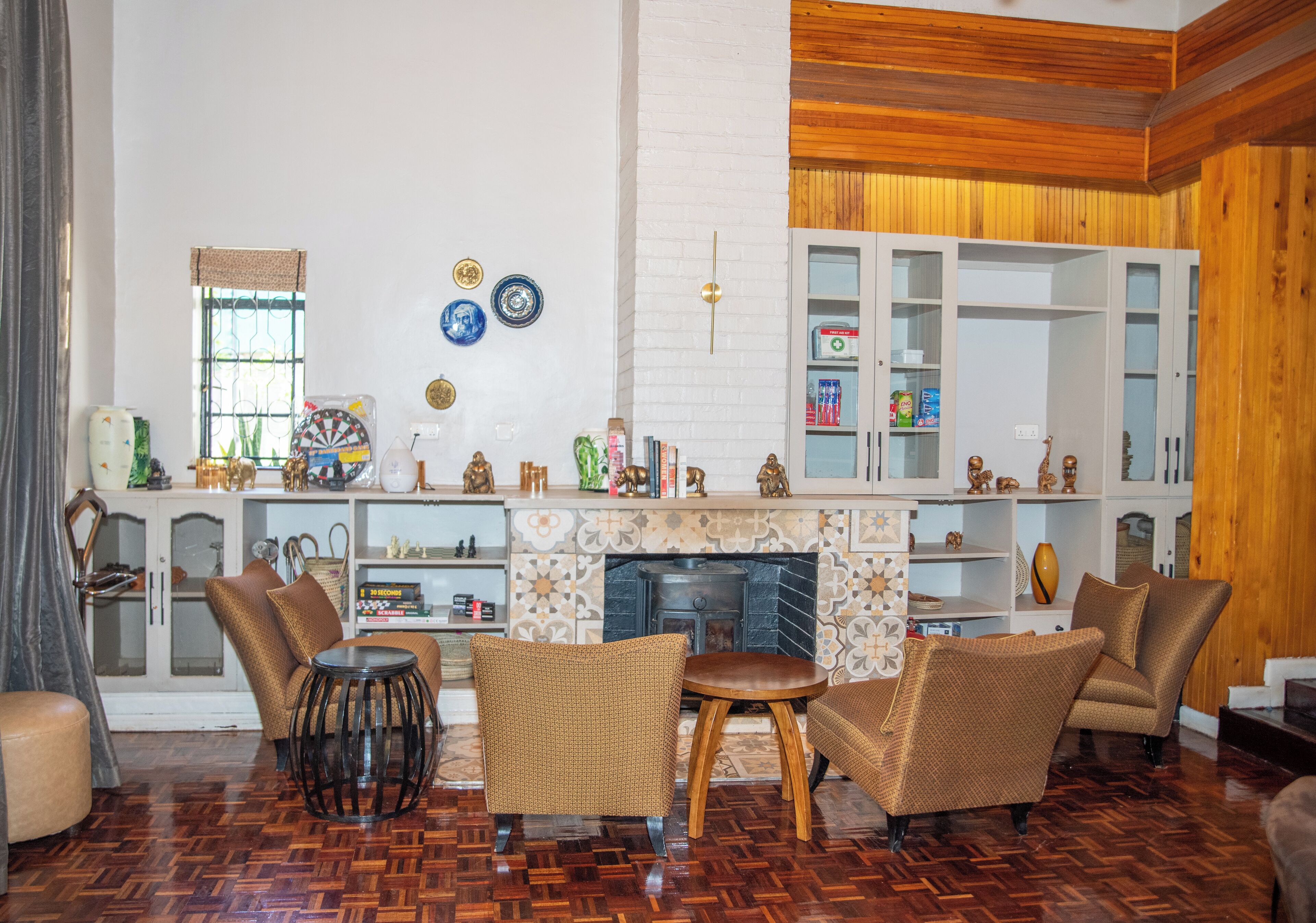 A living room with a fireplace, wicker chairs, and a wooden floor.