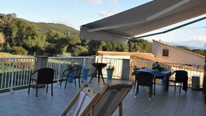A terrace with outdoor furniture, a table, and chairs, overlooking a hilly landscape. - Duplex 6 people in Corsica in residence with swimming pool (Serra-di-Ferro)