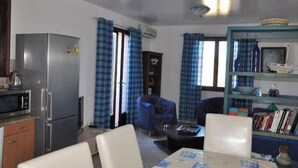 A compact living space with a kitchenette, a dining area, and a seating area with curtains. - Duplex 6 people in Corsica in residence with swimming pool (Serra-di-Ferro)