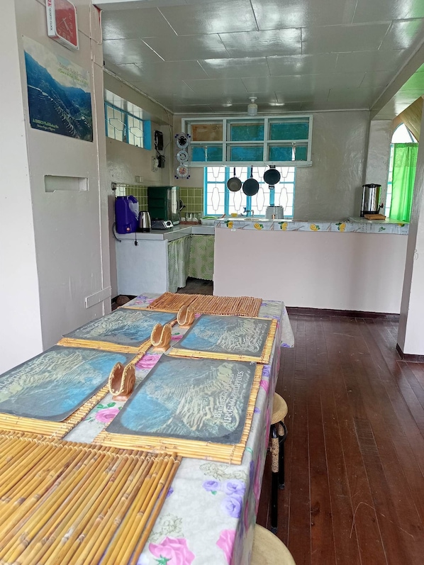 Una habitación amplia con una cama grande, una pequeña cocina y una mesa de comedor.