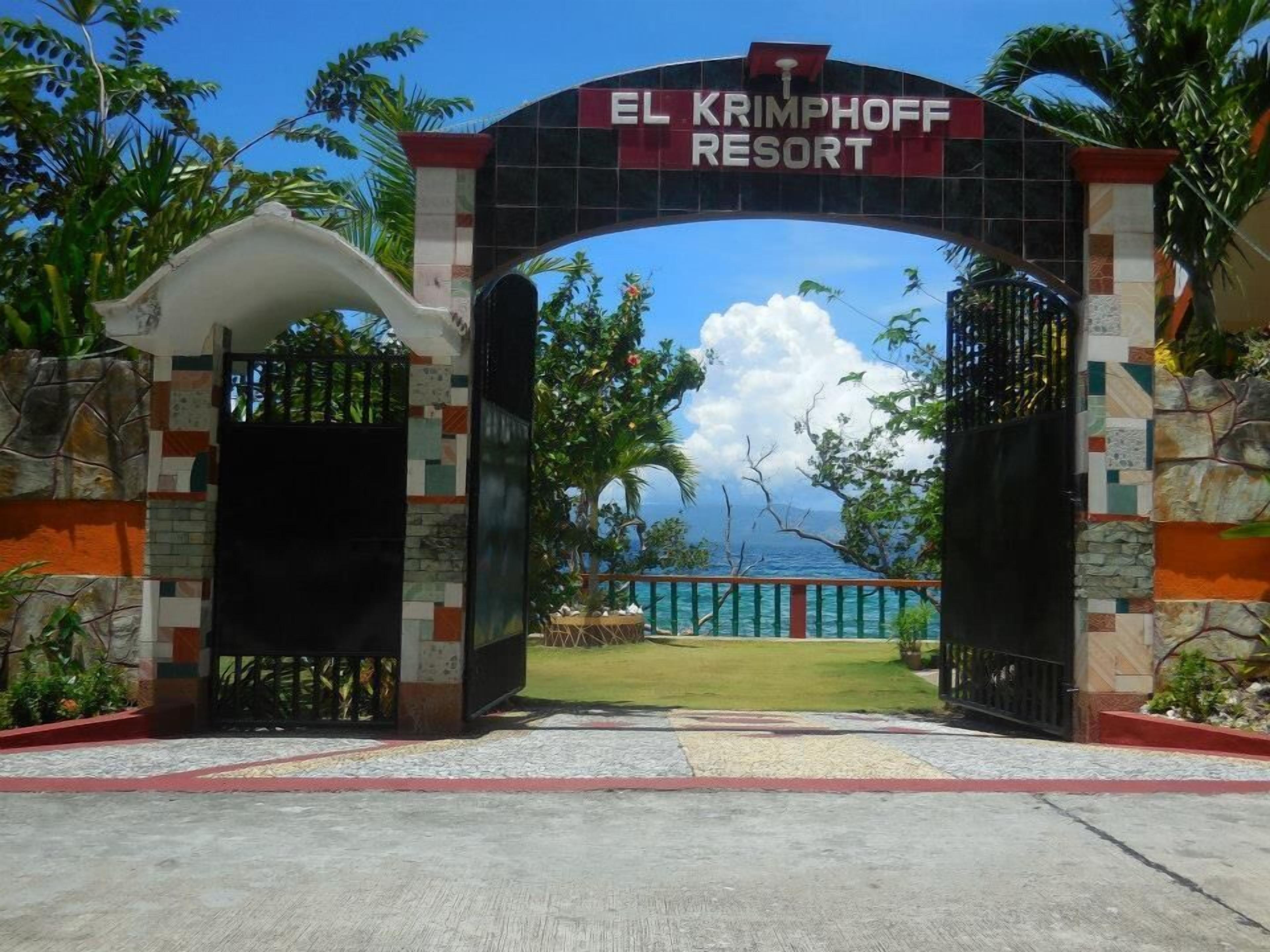 A entrada do Resort El Krimphoff, com vista clara para o oceano e paisagem tropical.