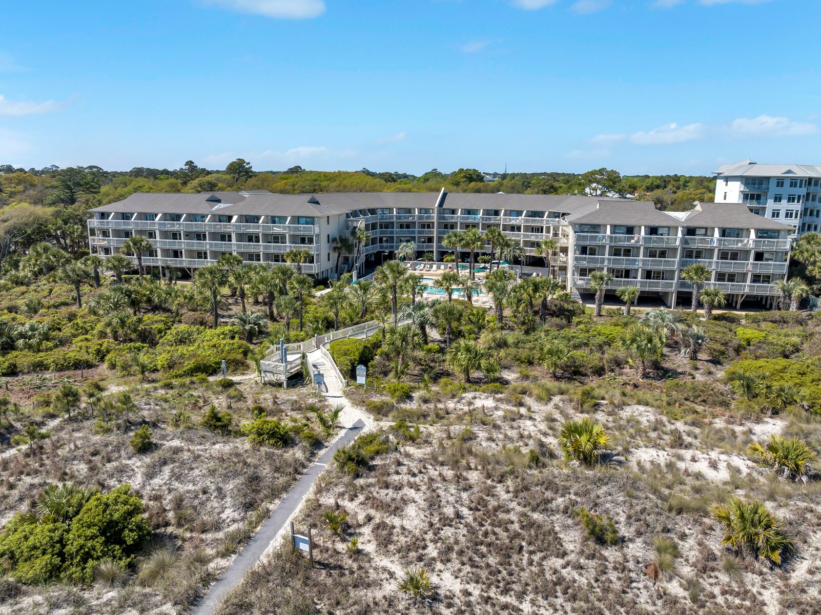 Ein Resort mit mehreren Gebäuden, einem zentralen Pool und einer umliegenden Naturlandschaft.