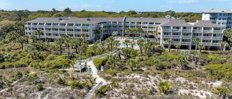 A resort with multiple buildings, a central pool, and a surrounding natural landscape.