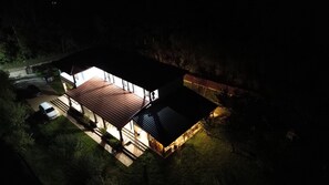 A two-story house with a red roof, a covered patio, and a fenced yard. - Pensiunea Emelys (Bârnova)
