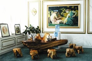 A room with a wooden coffee table, framed artwork on the wall, and a potted plant. - Fangyuan Hotel (Haiyang)