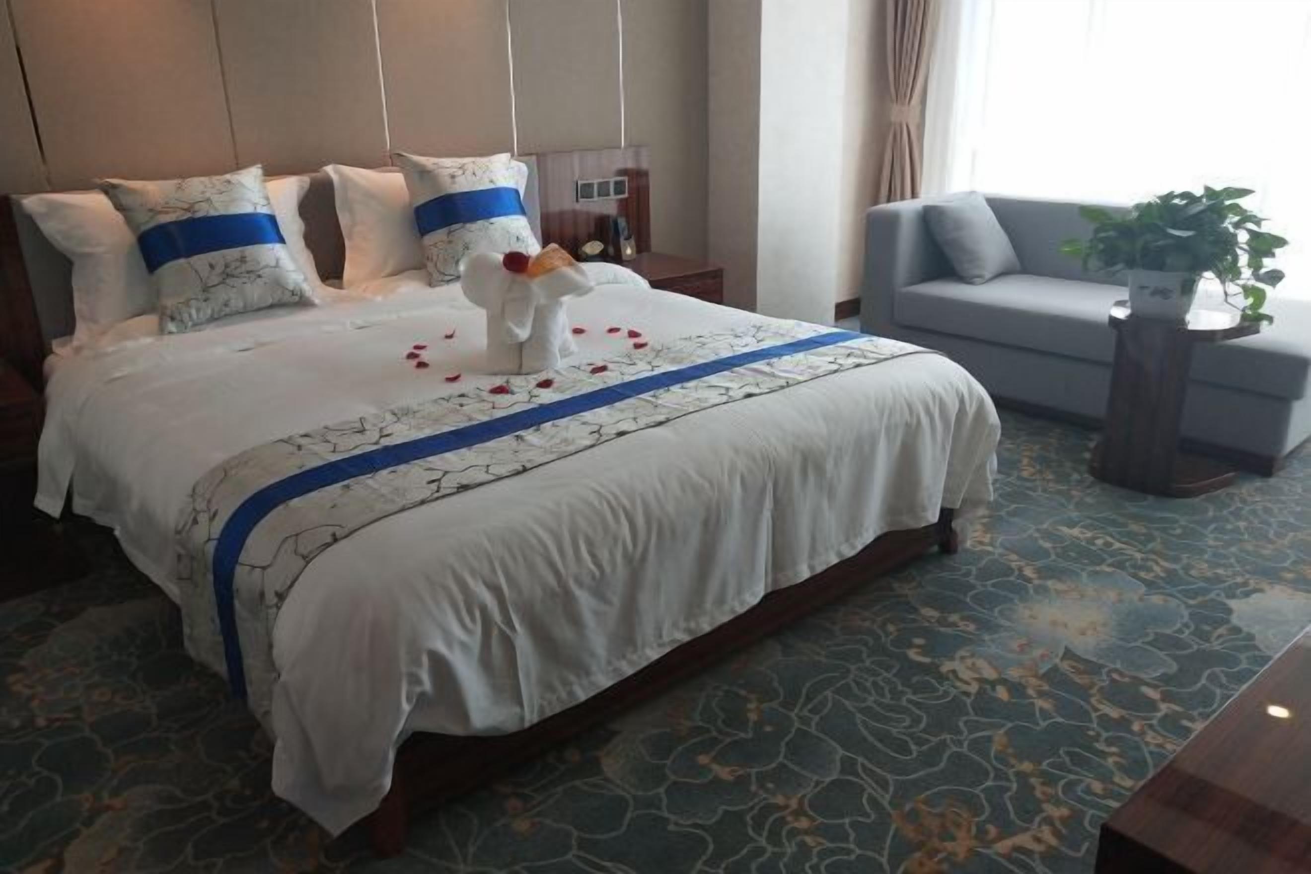 Ett hotellrum med en stor säng, en soffa och ett litet bord.