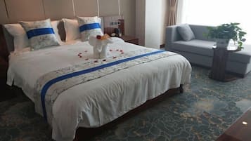 Ett hotellrum med en stor säng, en soffa och ett litet bord.