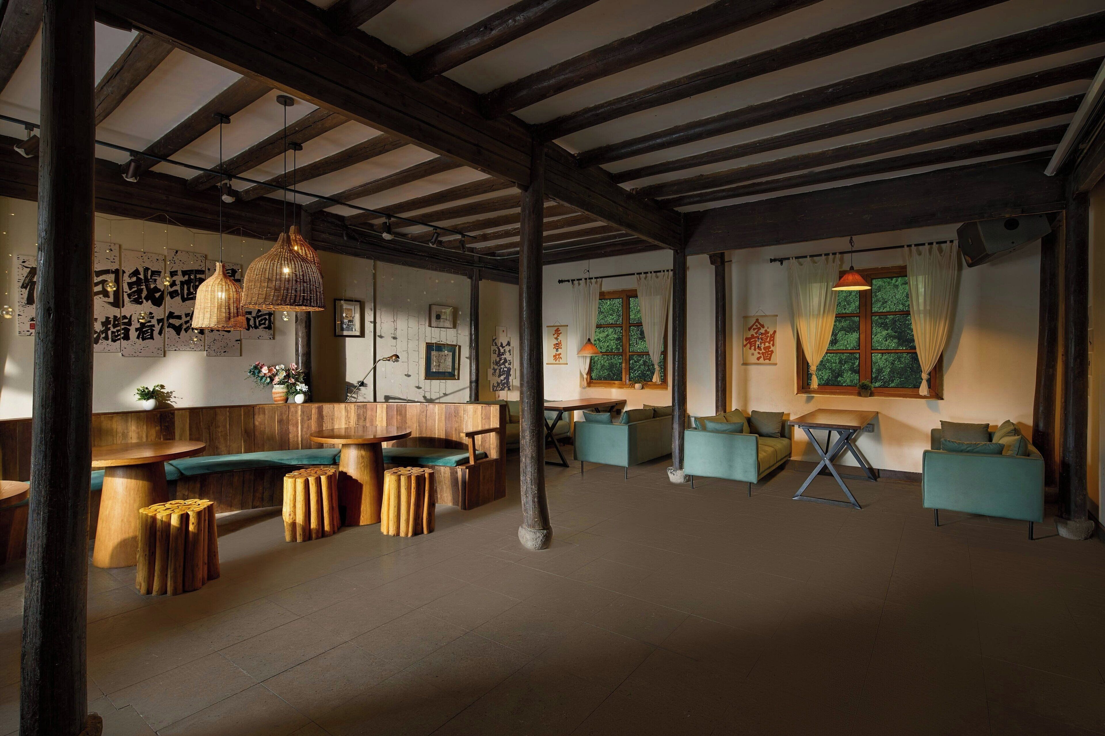 A spacious interior with wooden furniture, a high ceiling with exposed beams, and traditional decor.