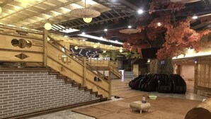 Et hotellobby med trappe, receptionsdisk og siddeområde.