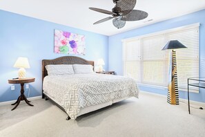 Cozy retreat with a large bed, bedside tables, and a ceiling fan.