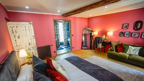 A bedroom with a large bed, a green sofa, and a wooden ceiling. - Le Fournil de Flavigny The Bakery rooms (Flavigny-sur-Ozerain)