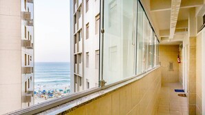 A corridor with a view of the beach and ocean. - Oceanview Apartment in Guarujá: Fast WiFi & Smart TV (Guarujá - SP)