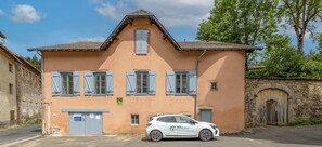 A two-story building with a car parked in front.