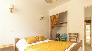 Une chambre à coucher comprenant un lit, des tables de chevet, une armoire et une chaise.