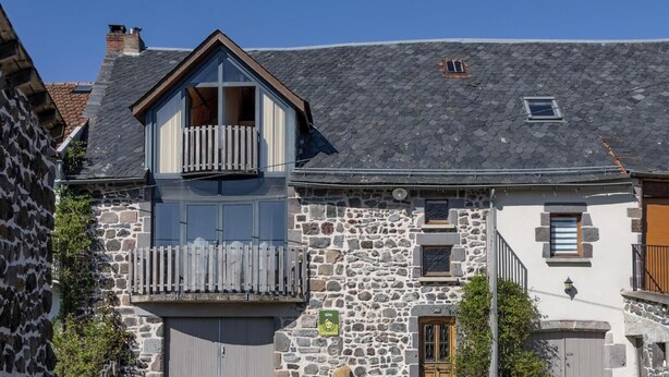 A stone building with a balcony, a small window, and a door. - Le Balladou - Vernines (VERNINES)