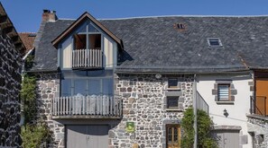A stone building with a balcony, a small window, and a door.