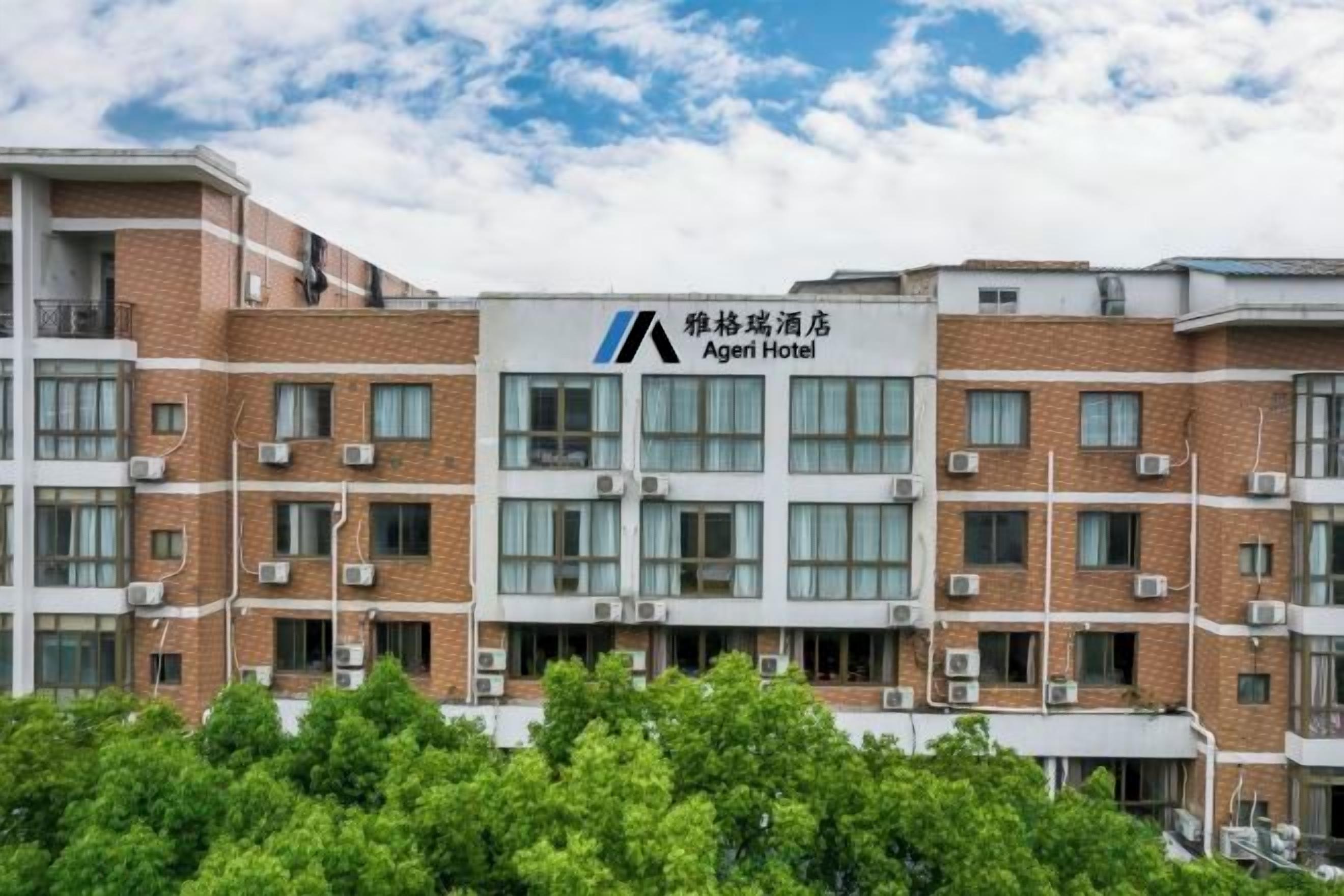 Un edificio de hotel con varios pisos, grandes ventanales y un logotipo destacado.