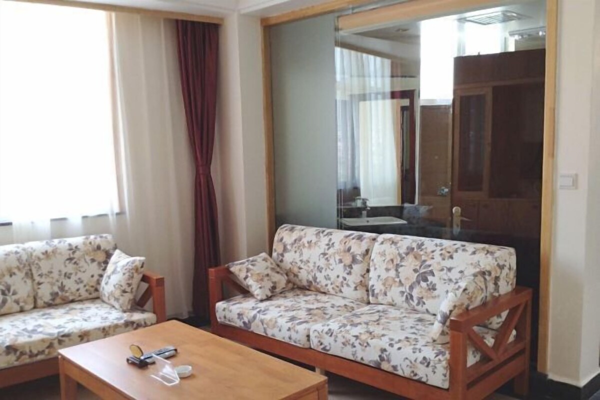 A living room with two sofas, a coffee table, and a large mirror.