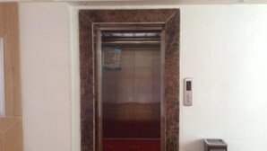 An elevator with a red carpet and a control panel on the wall. - Yunti Hotel (Jinping)