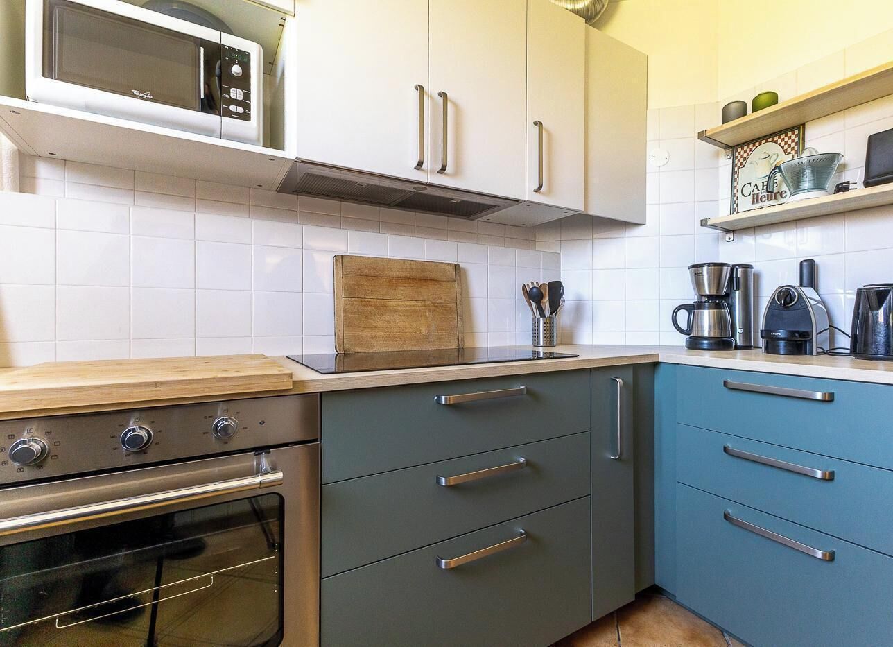 A kitchen with a microwave, stove, and drawers.