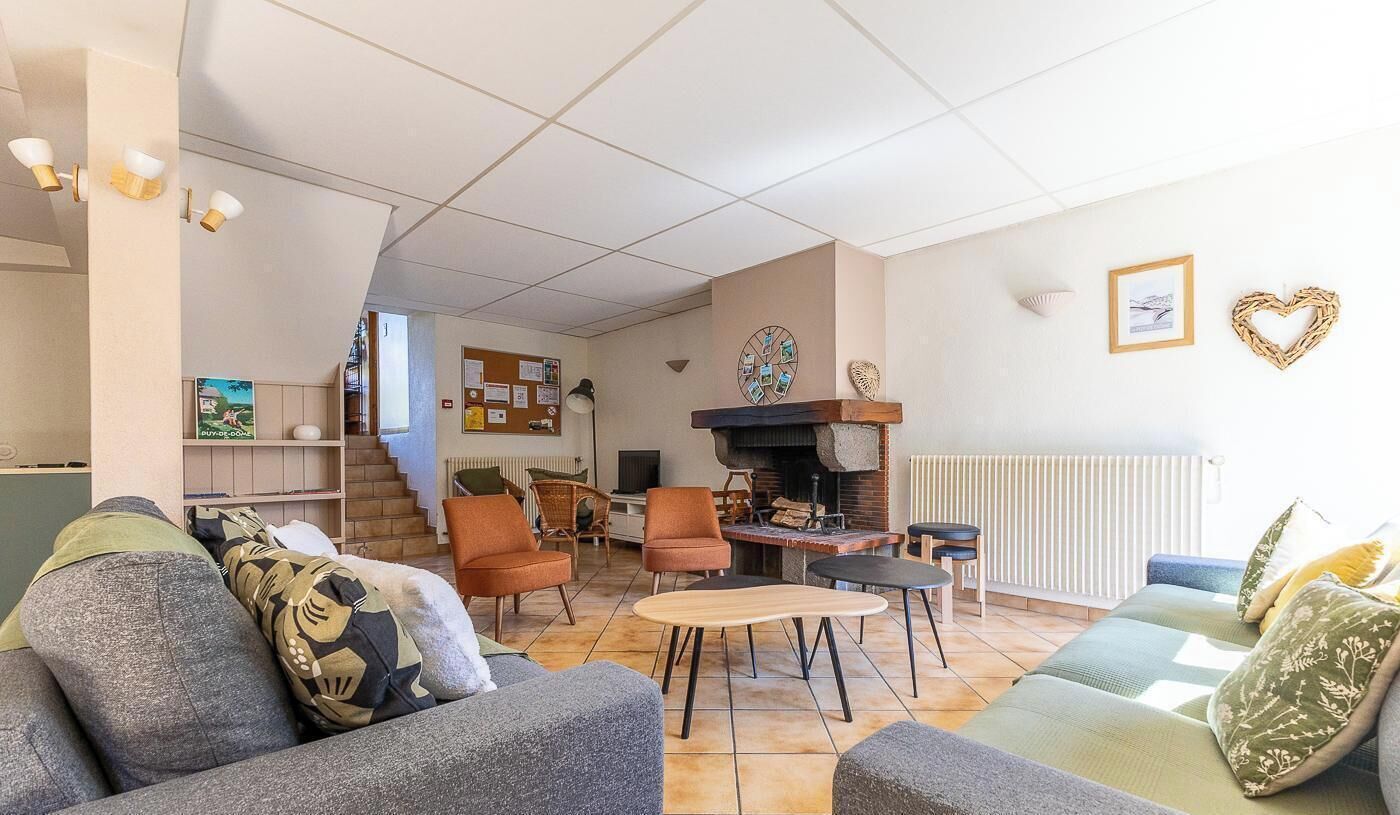 Una sala de estar con chimenea, sofás, sillones y una mesa de centro.