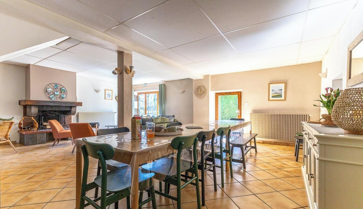 Un amplio espacio de sala con chimenea, una mesa de comedor y una zona de cocina.