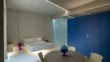 A modern bedroom with a bed, a round table, and a blue wardrobe.