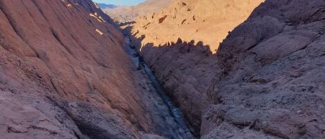A canyon with steep, rocky walls and a narrow passageway.