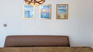 Una habitación con cabecera de madera, lámpara colgante de madera y tres cuadros en la pared.